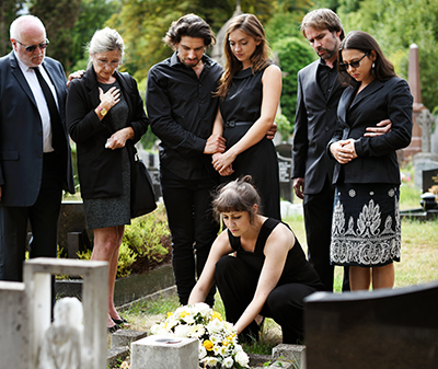 family-placing-flowers-on-grave.png